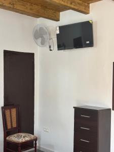 a room with a tv on the wall and a chair at Casa cubo in Alhama de Granada