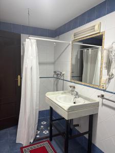 a bathroom with a sink and a mirror and a shower at Casa cubo in Alhama de Granada +2 photos