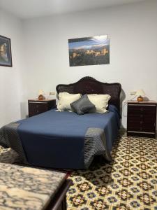 a bedroom with a blue bed with two night stands at Casa cubo in Alhama de Granada