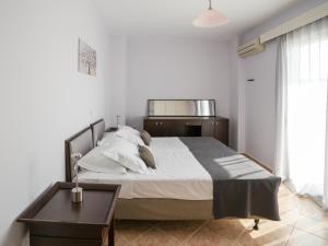 a bedroom with a large bed and a table at Patrikon House in Kardamaina