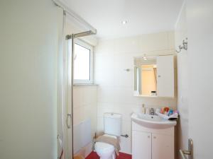 a white bathroom with a toilet and a sink at Patrikon House in Kardamaina +16 photos