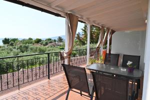 a patio with a table and chairs on a balcony at Sissy's Suites San Antonio Beach Potos Thassos in Potos