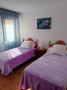 two beds in a room with purple sheets at B&B Santiago de Redecilla del camino in Redecilla del Camino