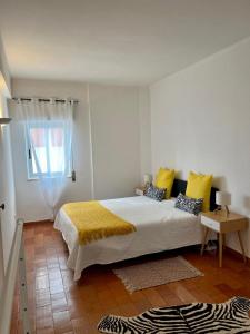 a bedroom with a bed with yellow pillows and a window at Sea Light Seaview Vista Mar Apartment - Luz, Lagos in Luz