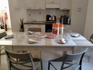 a kitchen with a table with plates and glasses on it at Bed breakfast L'AMICO in Alghero