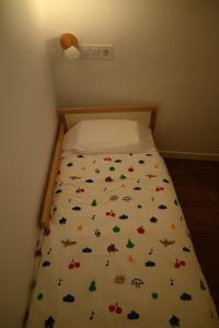 a bed with a white bedspread with butterflies on it at Casa en casco antiguo de Barbate in Barbate +2 photos