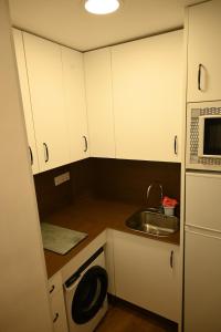 a small kitchen with a sink and a microwave at Casa en casco antiguo de Barbate in Barbate
