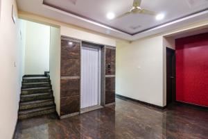 a hallway with stairs and a red door and a ceiling at Capital O N R Residency in Bengaluru