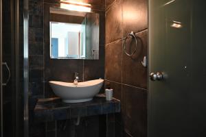 a bathroom with a sink and a mirror at Sissy's Suites San Antonio Beach Potos Thassos in Potos +55 photos