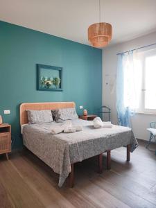 a bedroom with a bed with a blue wall at Il Giardino di Eva - Holiday Home - intero alloggio in Solferino