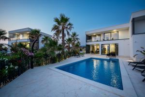 an exterior view of a house with a swimming pool at Villa London in Novalja