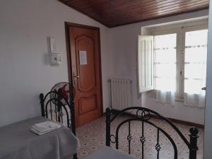 a bedroom with a bed and a window and a door at Antichi Sapori da Speranza in Gavoi