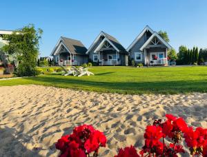 dom na plaży z czerwonymi kwiatami na piasku w obiekcie Mała Finlandia - luksusowe domki w Sarbinowie w Sarbinowie