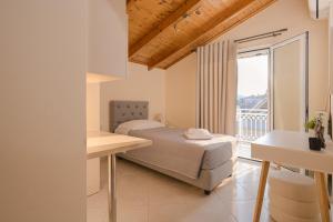 a bedroom with a bed and a balcony at Meltemi apts Charming Penthouse in Zakynthos Town