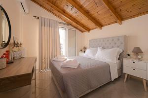 a bedroom with a white bed and a window at Meltemi apts Charming Penthouse in Zakynthos Town