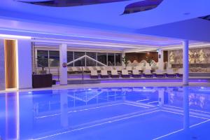 a pool in a hotel with chairs and tables at Grand Lubicz Uzdrowisko Ustka in Ustka