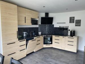 a large kitchen with wooden cabinets and appliances at Confortable Appartement près de Metz pour 6 personnes in Ban-Saint-Martin