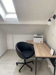 a black chair sitting at a desk in a room at Confortable Appartement près de Metz pour 6 personnes in Ban-Saint-Martin +4 photos