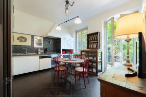 a kitchen with a table and chairs and a kitchen with white cabinets at Villa Angela in Florence