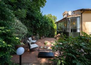 a patio with a chair and a table in a garden at Villa Angela in Florence
