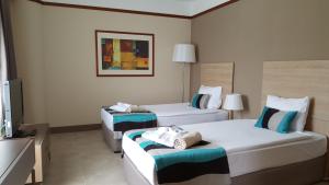Habitación de hotel con 2 camas y TV de pantalla plana. en Sundance Resort, en Turgutreis