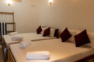 two beds in a room with towels on them at Ocean Bloom Villa in Trincomalee