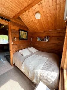 a bedroom with a bed in a wooden cabin at Vuorijärvi cottage in Enonkoski +27 photos