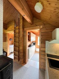 a kitchen with wooden walls and a wooden ceiling at Vuorijärvi cottage in Enonkoski