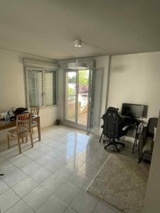 un salon avec une télévision, une table et des chaises dans l'établissement Superbe appartement à Lyon8 avec 2 balcons, à Lyon