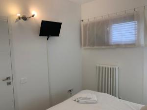a bedroom with a bed and a window and a television at Appartamento La Jolla Fano in Fano +44 photos