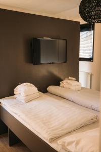 twee bedden in een kamer met een tv aan de muur bij Holiday Home Maridu Wellness in Arnhem +48 foto's