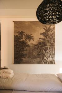 een schilderij aan een muur naast een bed bij Holiday Home Maridu Wellness in Arnhem