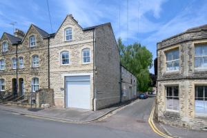 an old brick building with a garage on a street at Carpenters Building in Cirencester