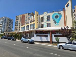 a street with cars parked in front of a building at Wellotel Chornomorsk in Chornomorsk