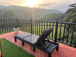 a black chair sitting on a balcony with a view at Casa Camiño do Eume in A Coruña