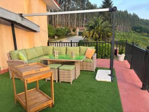 a patio with a couch and a table on grass at Casa Camiño do Eume in A Coruña