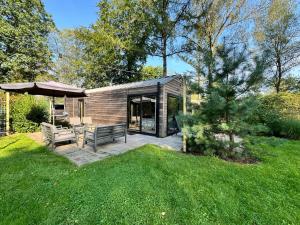 een klein huis met een patio en een parasol bij Holiday Home Maridu Wellness in Arnhem