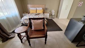 a bedroom with a bed and a chair with a pillow at Motse River Lodge in Vosburg
