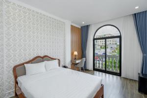 a bedroom with a bed and a large window at Hồng Hải Hotel in Pleiku