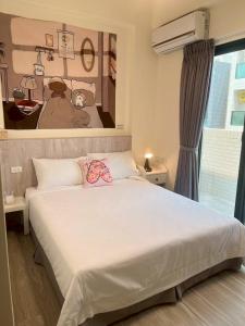 Un dormitorio con una cama blanca con un cuadro en la pared. en Jia Zizai B&B, en Magong