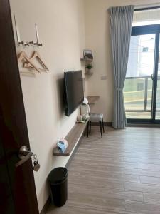 Una habitación con un televisor de pantalla plana en una pared. en Jia Zizai B&B, en Magong 18 fotos más