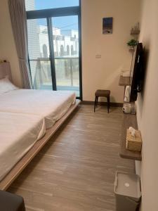 Una habitación de hotel con una cama y una ventana grande. en Jia Zizai B&B, en Magong