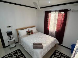 a small bedroom with a bed and a window at Silagi Holiday Home in Nadi