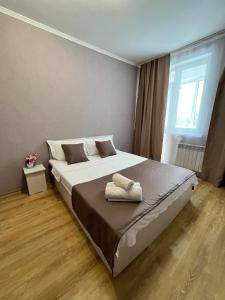 a bedroom with a bed with two towels on it at EmmaApart Comfort 169 in Astana