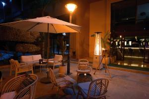 a patio with chairs and a table with an umbrella at Rawabi Hotel Marrakech & Spa in Marrakesh