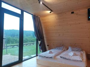a bedroom with two beds and a large window at Vila Isidora Berovo in Berovo
