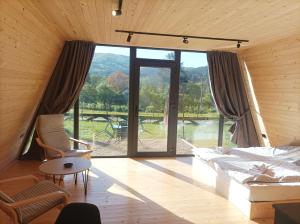 a living room with a bed and a large window at Vila Isidora Berovo in Berovo
