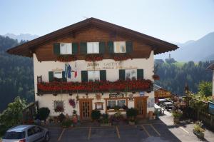 a building with flowers in front of it at Gasthof La Pli Apartments in San Vigilio Di Marebbe +14 photos
