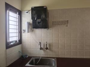 a kitchen with a sink and a window at Raja Accommodation in Kovilpatti