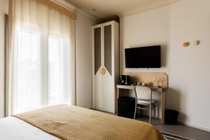a bedroom with a bed and a desk and a television at Domus Terravecchia in Agrigento